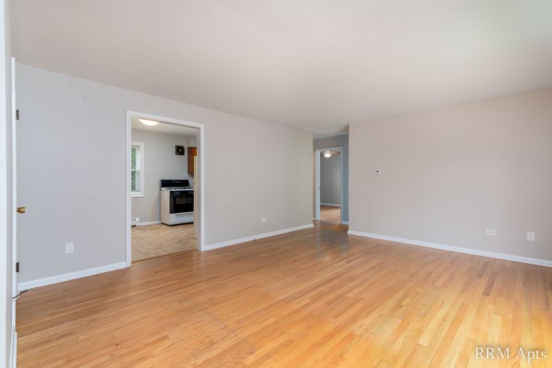 Living room with wood floor, gray walls and a doorway to the kitchen, Austin Avenue apartment 116 A