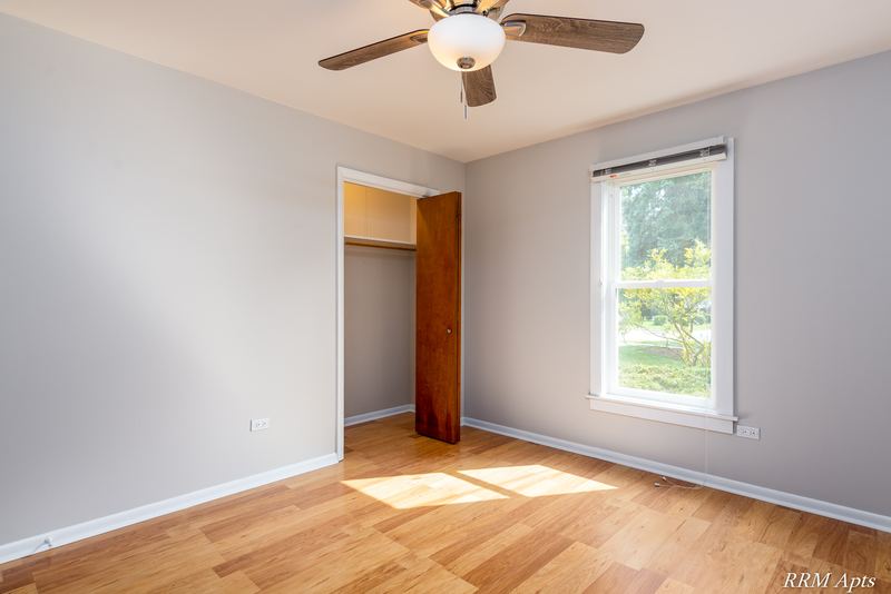 Bedroom with wood floor, ceiling fan, one window and an open closet on the left, Austin Avenue apartment 120 A