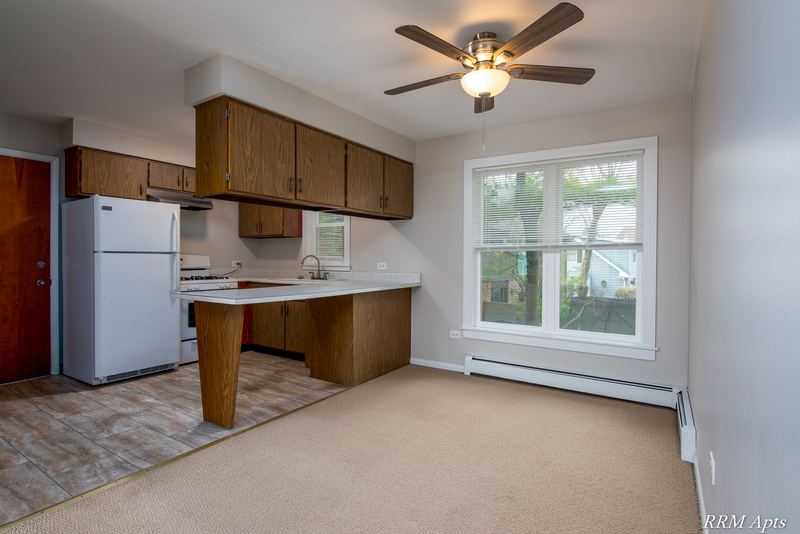 Kitchen with dark wood cabinets, white refrigerator, peninsula counter and a ceiling fan, Austin Avenue apartment 122 B