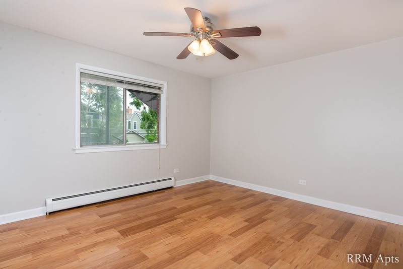 Bedroom with wood floor, ceiling fan, one window and baseboard radiator, Cook Street apartment 4