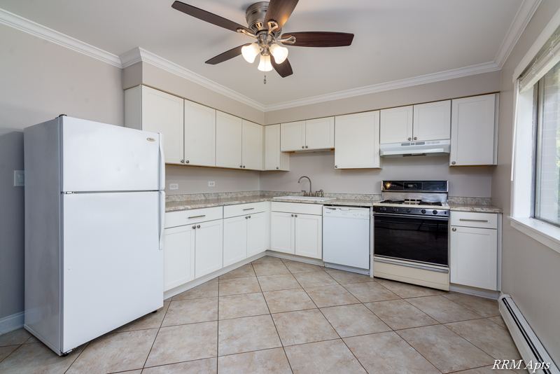 Kitchen with white cabinets, white refrigerator, dishwasher, gas stove, ceiling fan and tile floor, Cook Street apartment 6