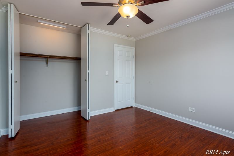 Bedroom with ceiling fan and open closet with sliding doors, Cook Street apartment 6