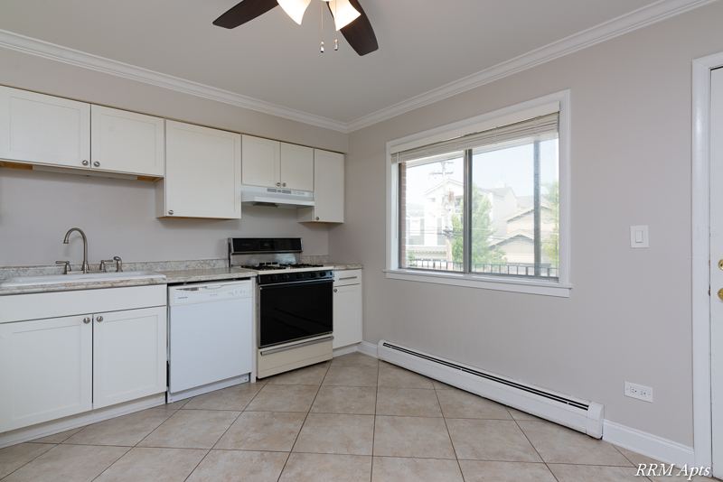 Kitchen with white cabinets, dishwasher, gas stove and window, Cook Street apartment 6