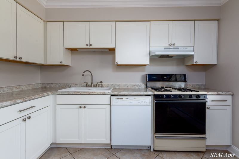 Kitchen with white cabinets, sink, dishwasher and stainless gas stove, Cook Street apartment 6