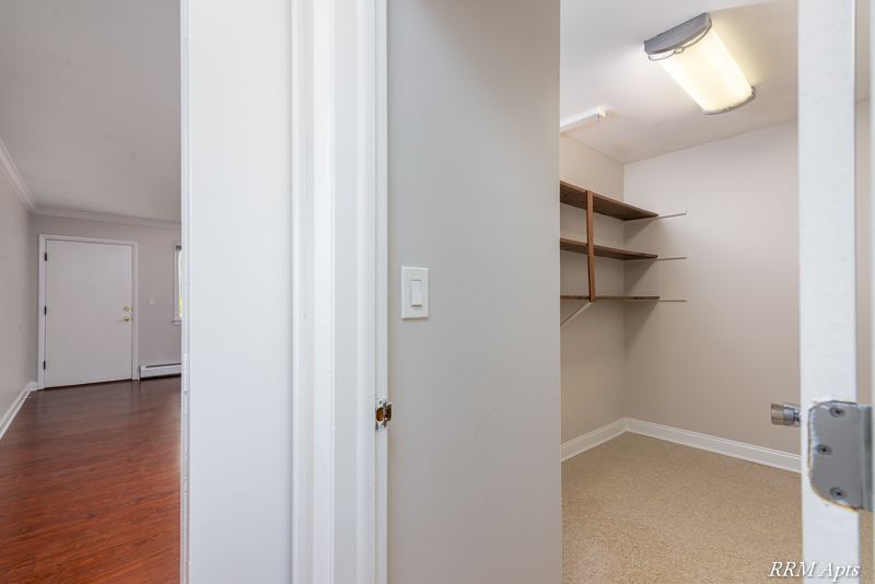 Hallway with a walk-in closet with shelves and the front door beyond, Cook Street apartment 6