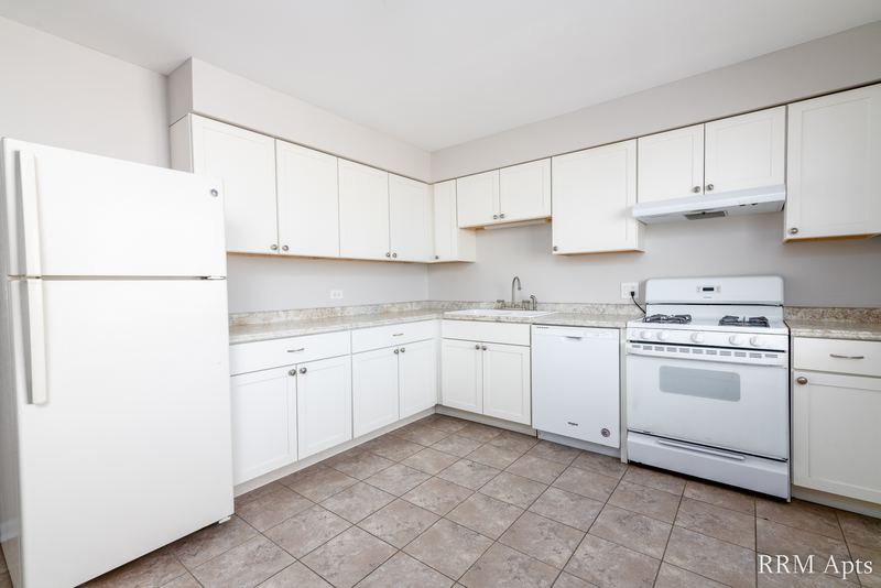 Kitchen with white cabinets, white refrigerator, white gas stove, range hood and tile floor, Cook Street apartment 9