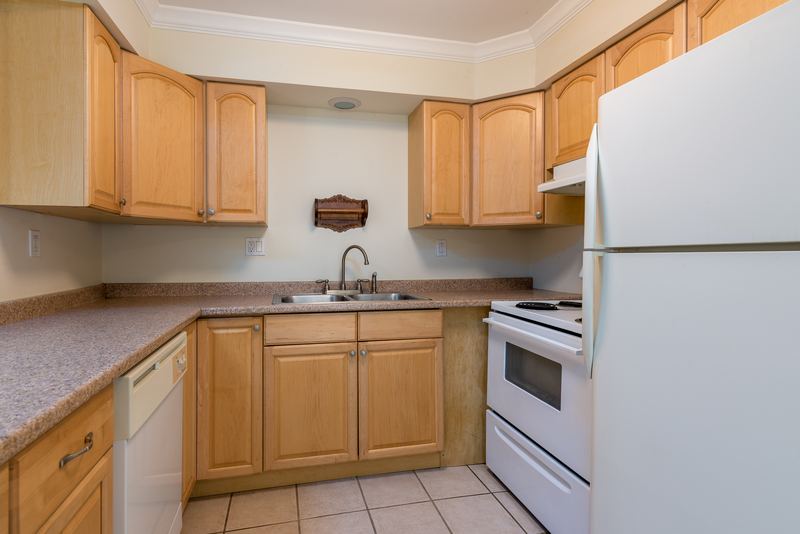 Kitchen with light oak cabinets, white refrigerator, white stove, white dishwasher and tile floor, Depot Road apartment 2
