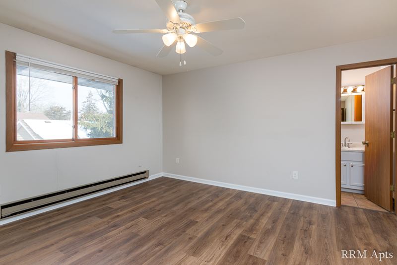 Bedroom with ceiling fan, window and door to the bathroom, Depot Road apartment 3