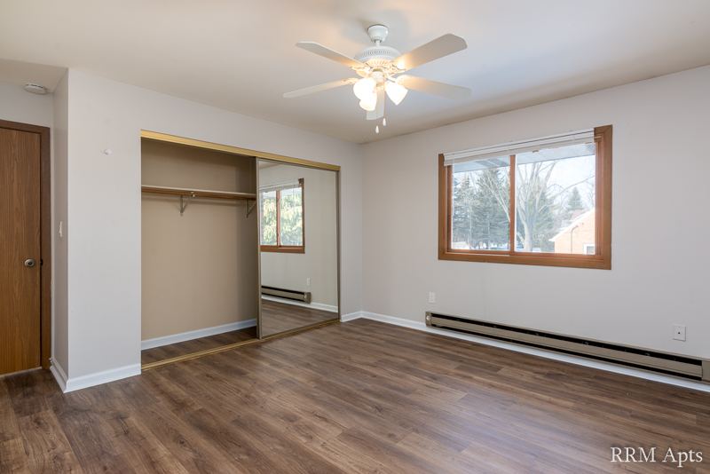 Bedroom with ceiling fan, window and wide closet with mirrored door, Depot Road apartment 3