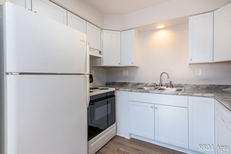 Kitchen with white cabinets, granite-look counter, white refrigerator and electric stove, Depot Road apartment 3
