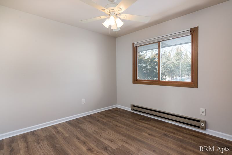 Bedroom with ceiling fan, window and wood-look floor, Depot Road apartment 3