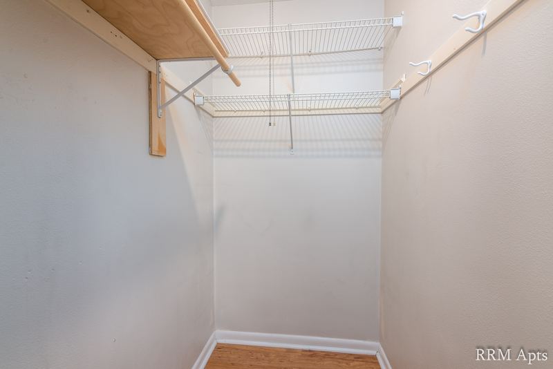 Closet with wire shelving and hanging rod, gray walls and carpeted floor, East Park apartment 2