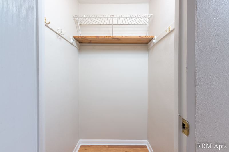 Closet with wire shelving and hanging rod, gray walls and wood floor, East Park apartment 3