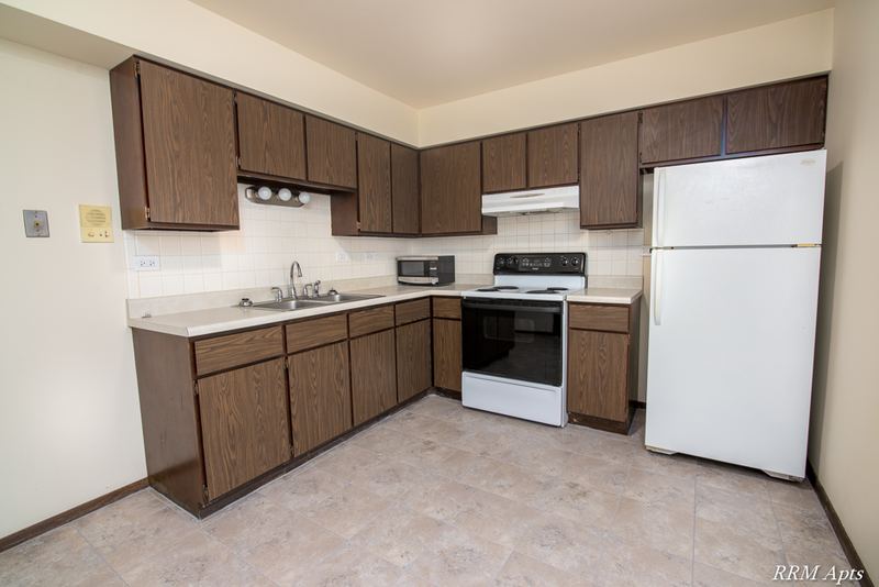 Kitchen with dark wood cabinets, sink, white stove, white refrigerator and tile floor, John Mogg apartment 32927 102 S