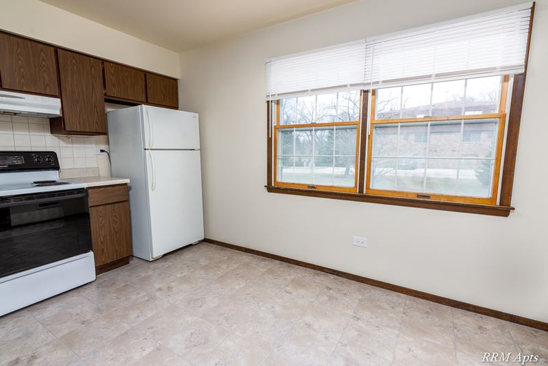Kitchen with dark wood cabinets, white stove, white refrigerator and a wood-trimmed window, John Mogg apartment 32927 102 S