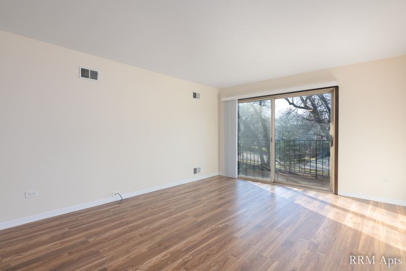 Living room with wood floor, cream walls and a sliding glass door to a balcony, John Mogg apartment 32927 203