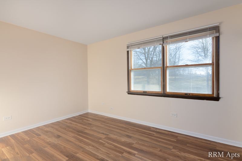 Bedroom with wood floor, cream walls and one wood-trimmed window, John Mogg apartment 32927 203