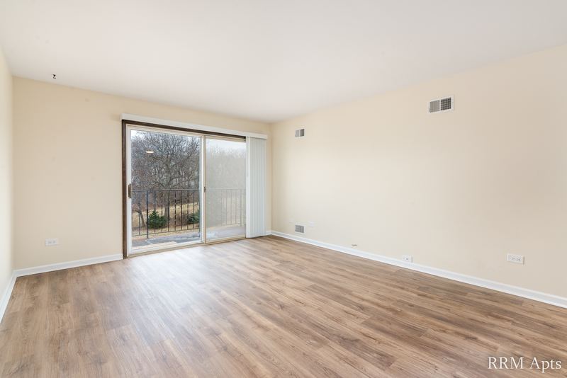 Living room with wood floor, cream walls and a sliding glass door to a balcony, John Mogg apartment 32927 301