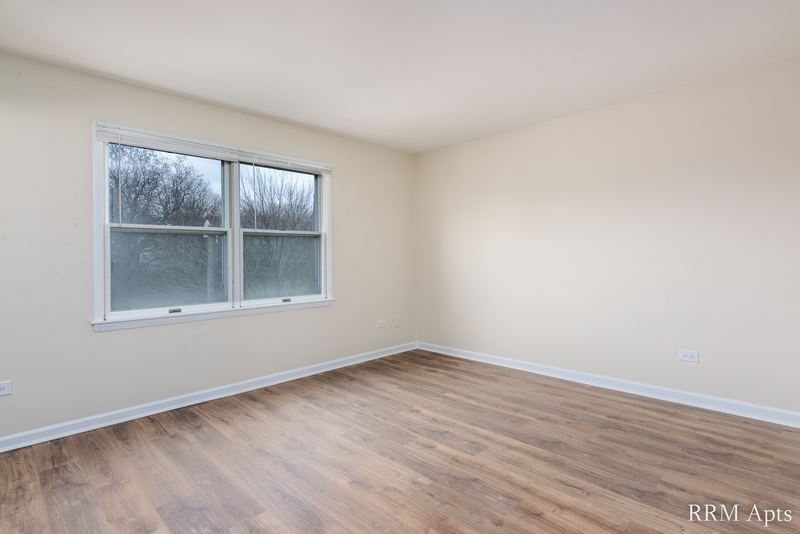 Bedroom with wood floor, cream walls and one white-trimmed window, John Mogg apartment 32927 301
