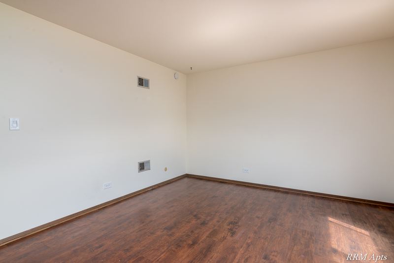 Bedroom with wood floor, cream walls and a wood door frame on the right, John Mogg apartment 32985 102