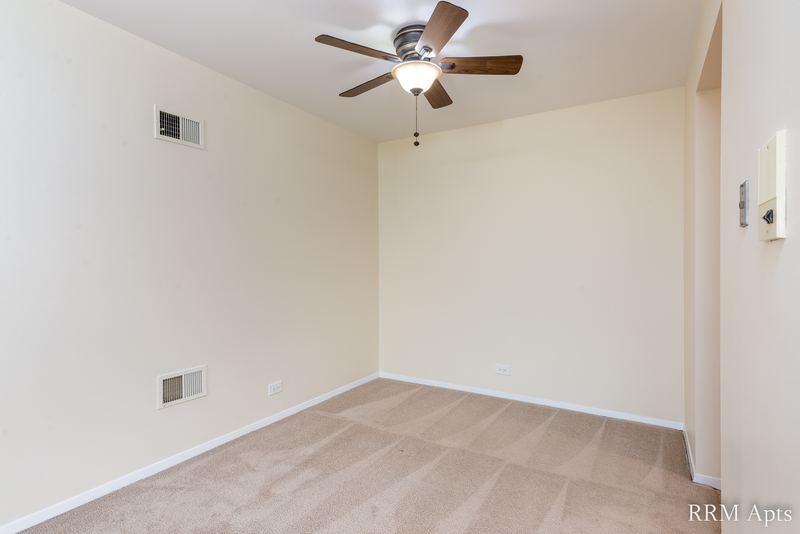 Empty carpeted room with ceiling fan and cream walls, John Mogg apartment 32985 301