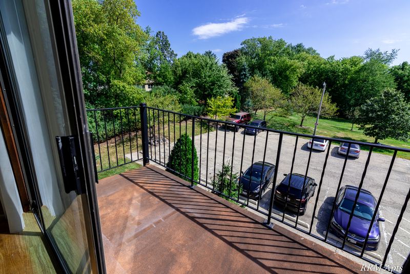 Balcony with black iron railing overlooking the parking lot and trees, John Mogg apartment 32985 302