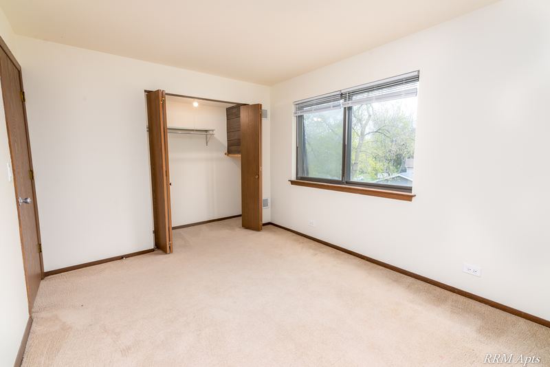 Bedroom with beige carpet, open closet, a window and the entry door, John Mogg apartment 32985 304 N