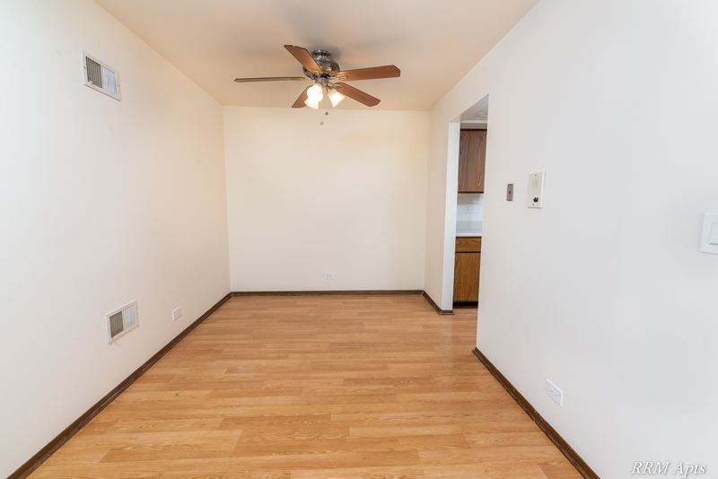 Dining area with wood laminate floor, ceiling fan with light and doorway to the kitchen, John Mogg apartment 32985 304 N