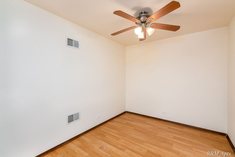 Dining area with wood laminate floor, ceiling fan with light and white walls, John Mogg apartment 32985 304 N