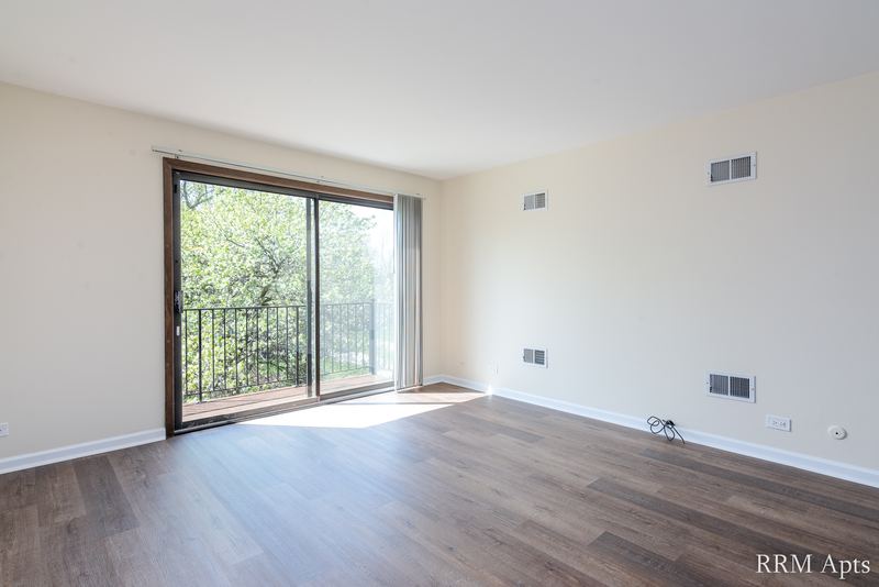 Living room with wood laminate floor and a sliding glass door to the balcony, John Mogg apartment 32985 304