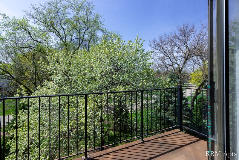 Balcony with black iron railing and a view into the tree canopy, John Mogg apartment 32985 304