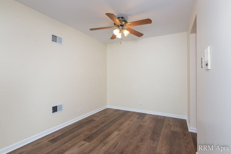Dining area with wood laminate floor and a ceiling fan with light, John Mogg apartment 32985 304