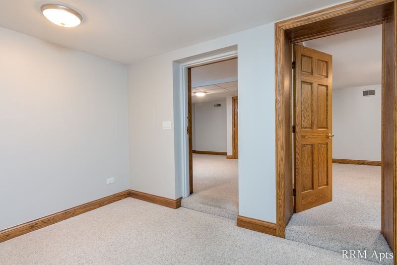 Empty room with beige carpet, wood trim doorways and a flush ceiling light, Maple Avenue apartment 101