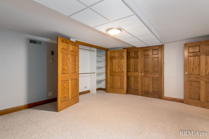 Bedroom with beige carpet, drop ceiling and wood closet doors open to shelves, Maple Avenue apartment 101