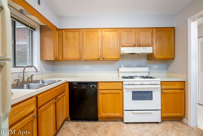 Kitchen with wood cabinets, stainless sink, black dishwasher, white gas stove and a window, Maple Avenue apartment 1E