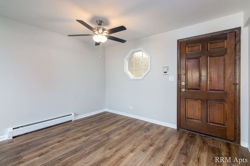 Entry with wood laminate floor, ceiling fan, octagon window and dark wood door, Maple Avenue apartment 1F