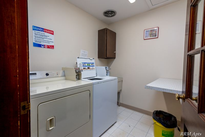 Laundry room with white washer and dryer, tile floor and a wall cabinet, Maple Avenue apartment 2C