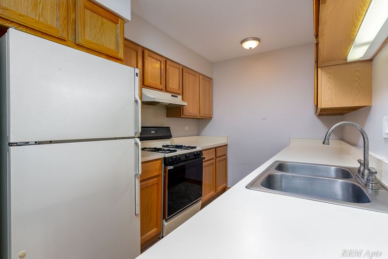 Kitchen with white refrigerator, wood cabinets, black stove and stainless double sink, Maple Avenue apartment 2C