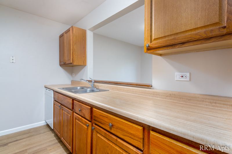Kitchen with oak cabinets, breakfast bar counter and dishwasher, Oriole Court apartment 1F