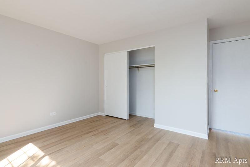 Bedroom with open closet and wood-look floor, Oriole Court apartment 1F