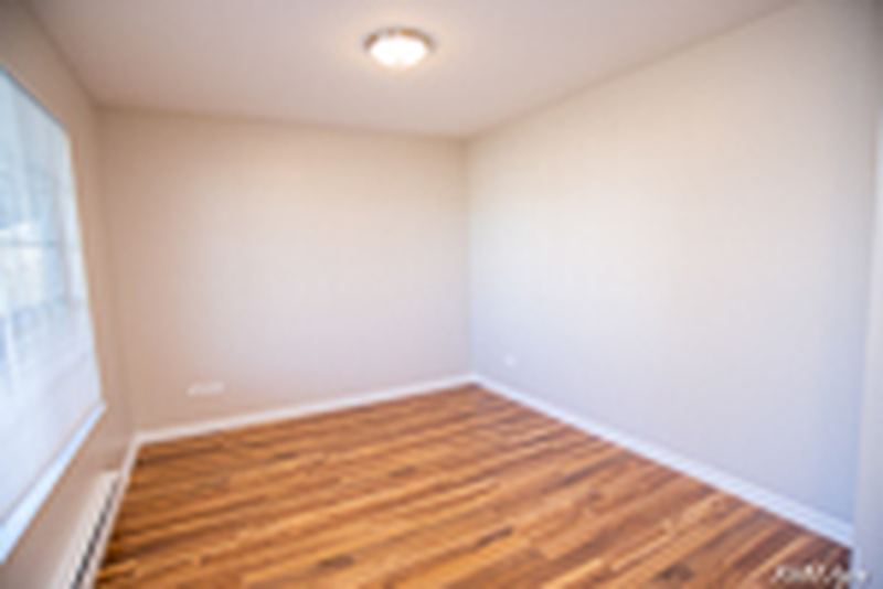 Empty room with wood laminate floor, flush ceiling light and baseboard heat, Oriole Court apartment 2D