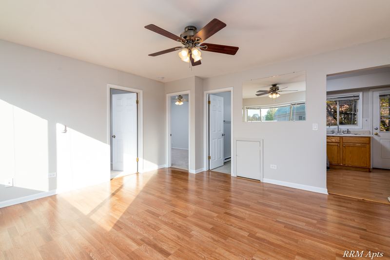 Living room with wood floor, ceiling fan and doorways to the hallway and kitchen, Park West apartment 611 C