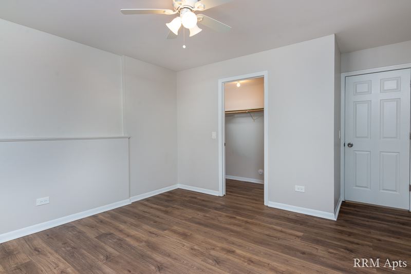 Living room with ceiling fan, walk-in closet and front door, Pioneer Court apartment 900-1A