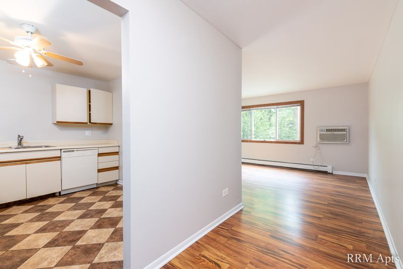 Kitchen with checkered tile floor, white cabinets and a view into the living room, Pioneer Court apartment 900 2A