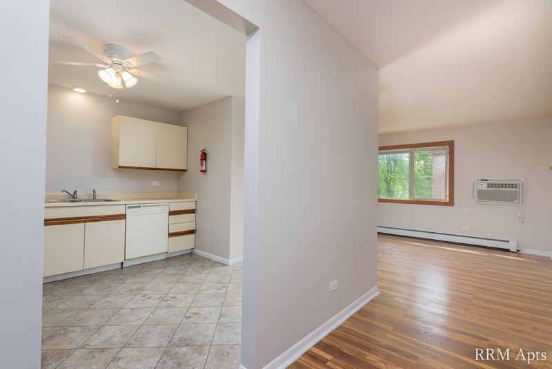 Hallway with tile floor between the white-cabinet kitchen and the living room, Pioneer Court apartment 900 3C