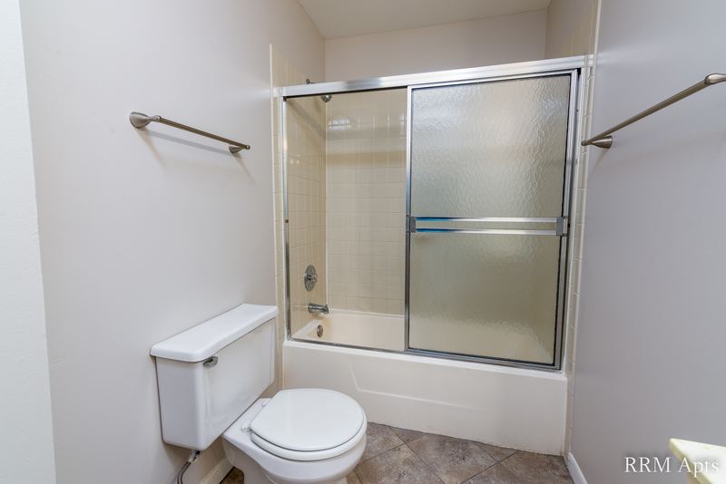 Bathroom with sliding glass tub doors, toilet and two towel bars, Pioneer Court apartment 900 3C