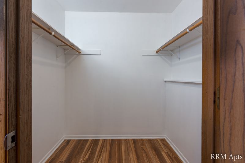 Closet with wood-look floor, oak door frame and a long shelf with a hanging rod, Pioneer Court apartment 918 1B