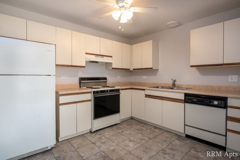 Kitchen with white oak-trimmed cabinets, white refrigerator, stove and dishwasher, Pioneer Court apartment 918 2A