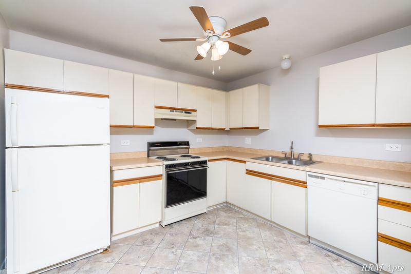 Kitchen with white cabinets, white refrigerator, stove, dishwasher and a ceiling fan, Pioneer Court apartment 918-2D