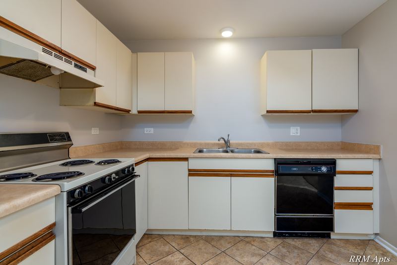Kitchen with white oak-trimmed cabinets, black stove, black dishwasher and a double sink, Pioneer Court apartment 918 3A